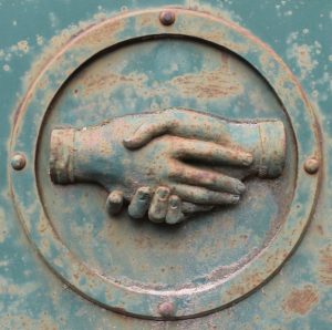 metal plaque depicting a handshake